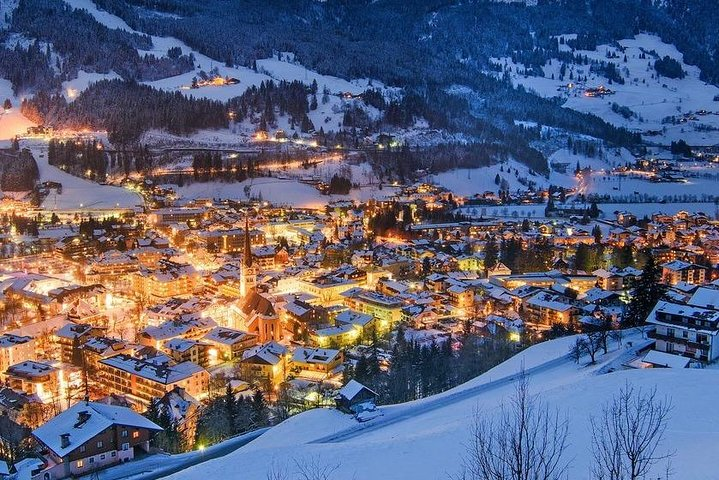 Experience the charm of winter evenings in Austria where twinkling lights illuminate snow-covered rooftops and scenic mountain landscapes perfect for a relaxing weekend getaway.